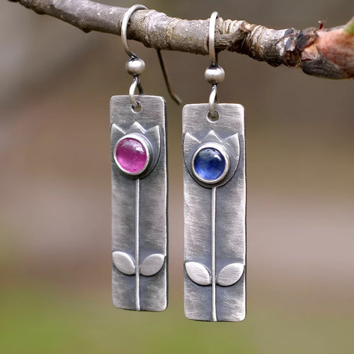 Antique finish red sapphire earrings with a geometric ellipse shape on electroplated metal.