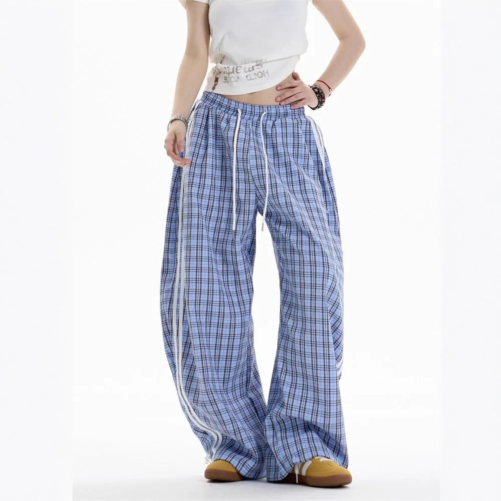 Blue loose straight wide leg polyester trousers with pockets and mid-waist design on a model