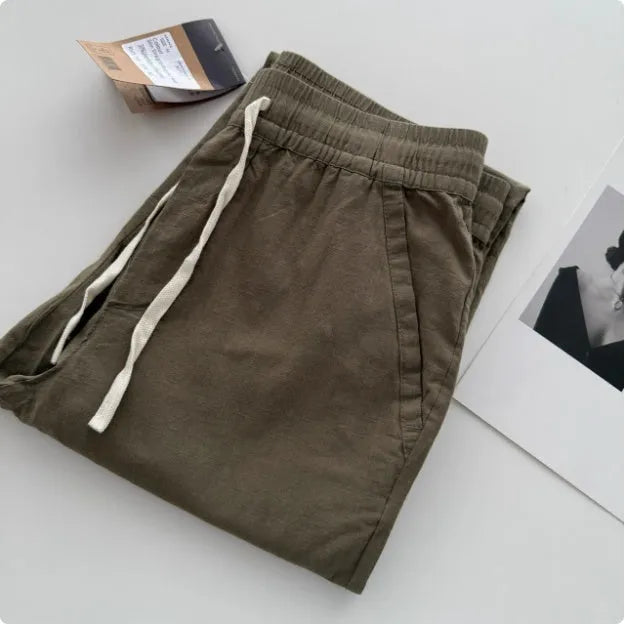 Man wearing beige loose straight casual pants with a drawstring waistband.