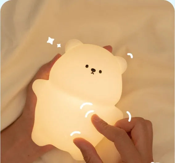 Lying flat bear silicone small night lamp with three-gear dimming and RGB colour switching on a bedside table