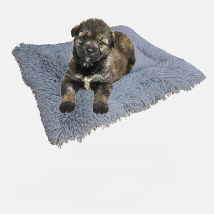 Grey fluffy pet sleeping pad for cats and dogs on a sofa, showing non-slip black bottom.