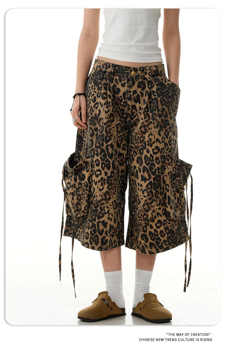 A pair of loose-fitting, high-waisted, straight-leg cropped pants in a leopard print pattern.
