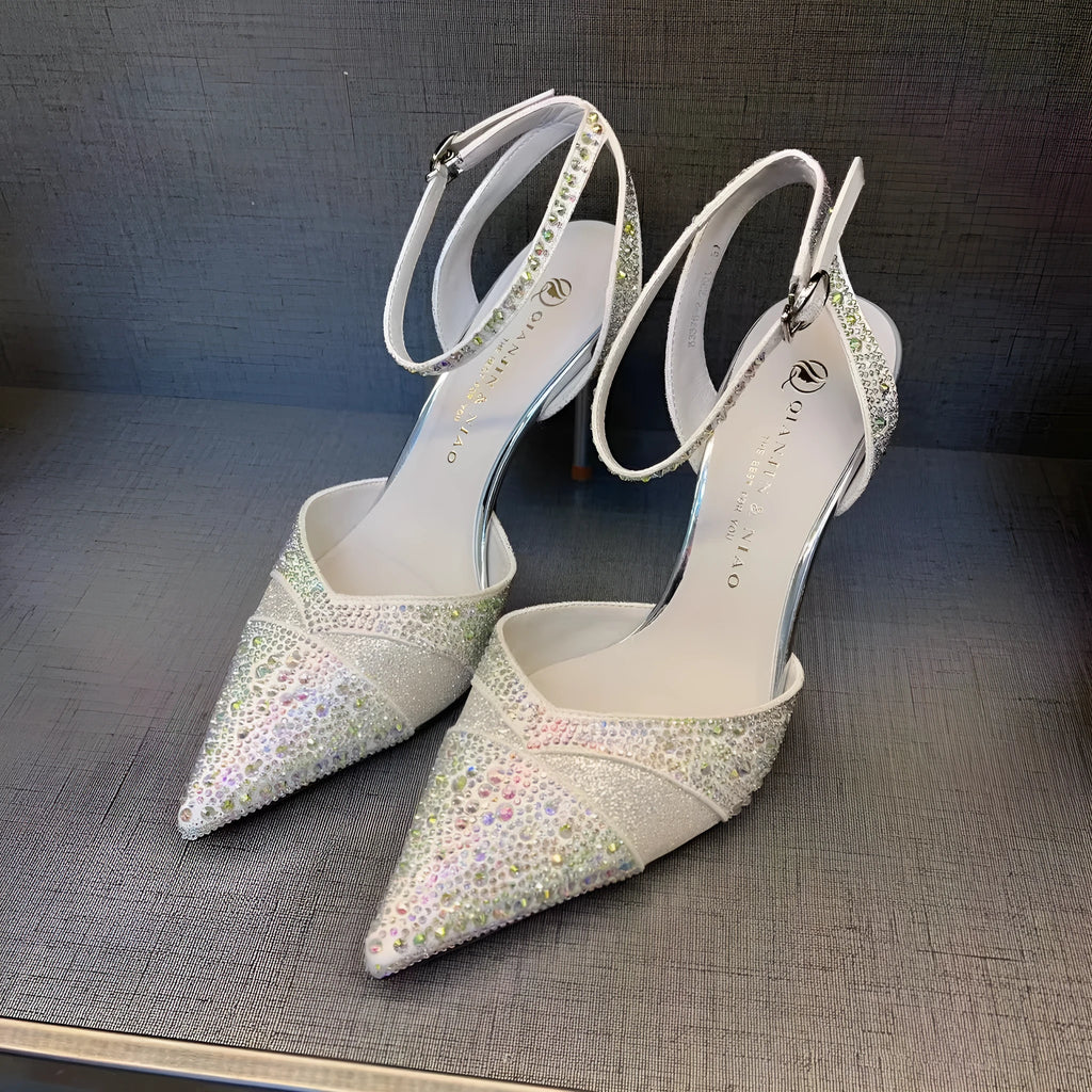 Women's black high heel shoe with a red sole, pointed toe, and a hollow stiletto heel on a plain background.