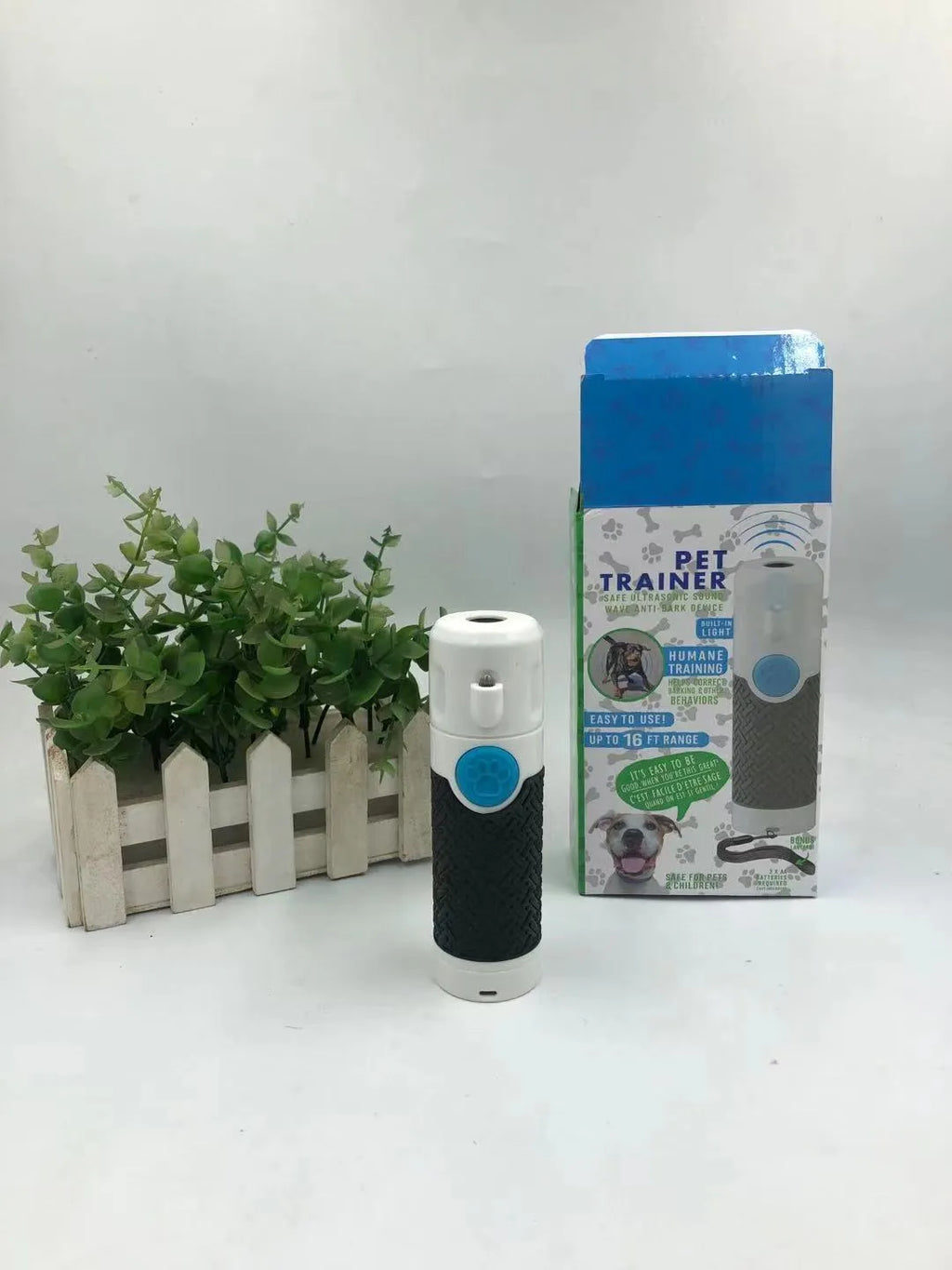 White handheld ultrasonic dog bark control trainer unit on a plain background.