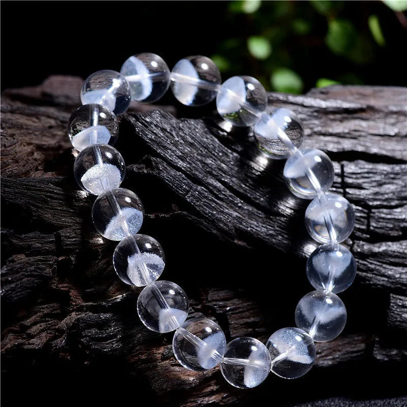 Women's adjustable white crystal ghost pyramid bracelet with Ruyi charm on wrist.