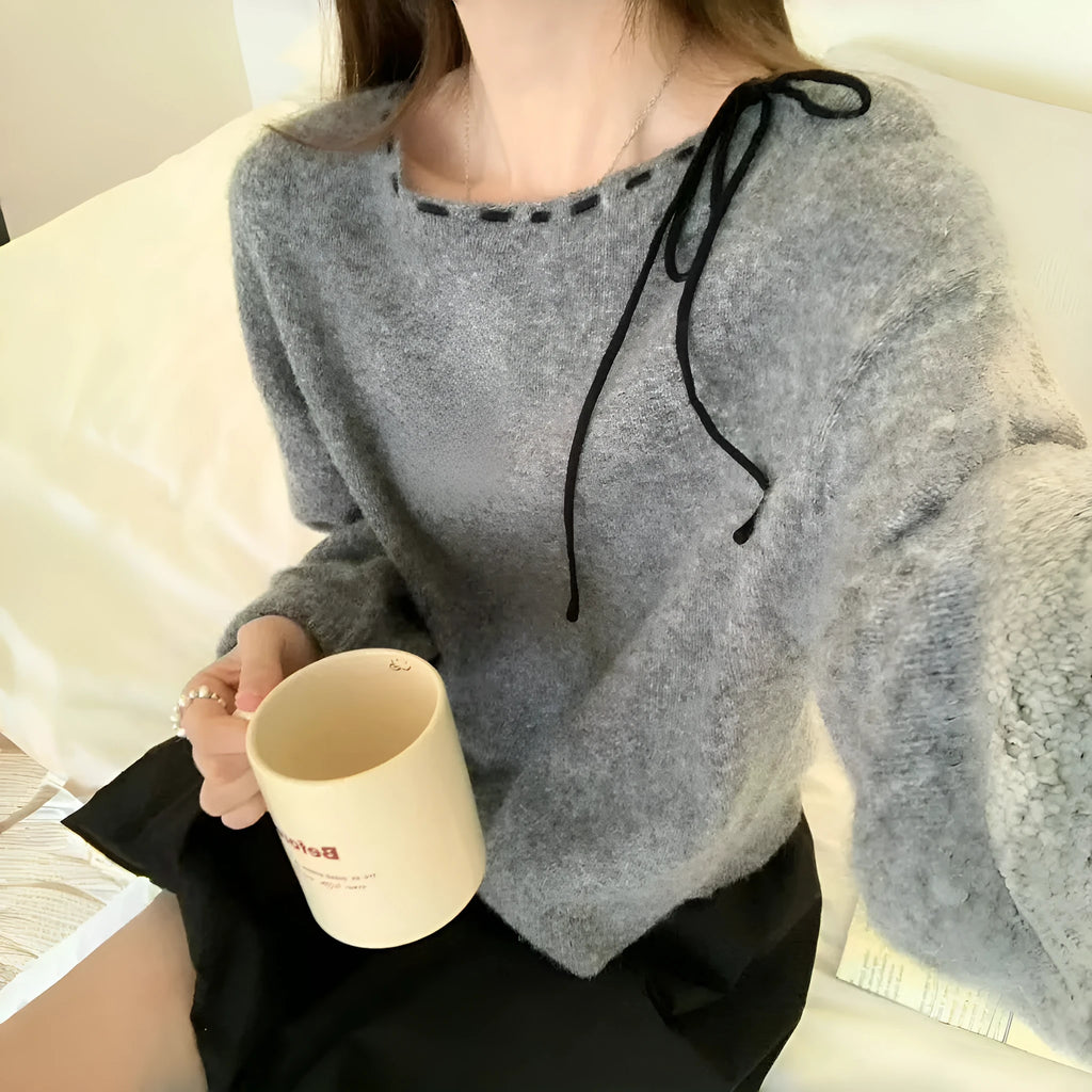 A grey loose-fitting women's knitwear pullover, shown on a hanger.