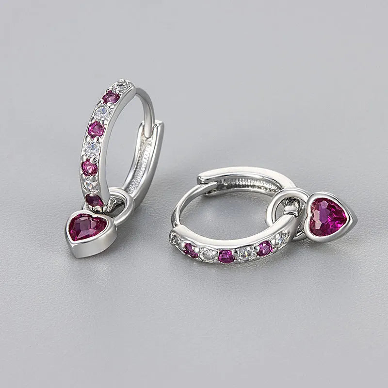 Women's heart-shaped drop earrings with coloured zircon or corundum stone in gold or white gold tone.