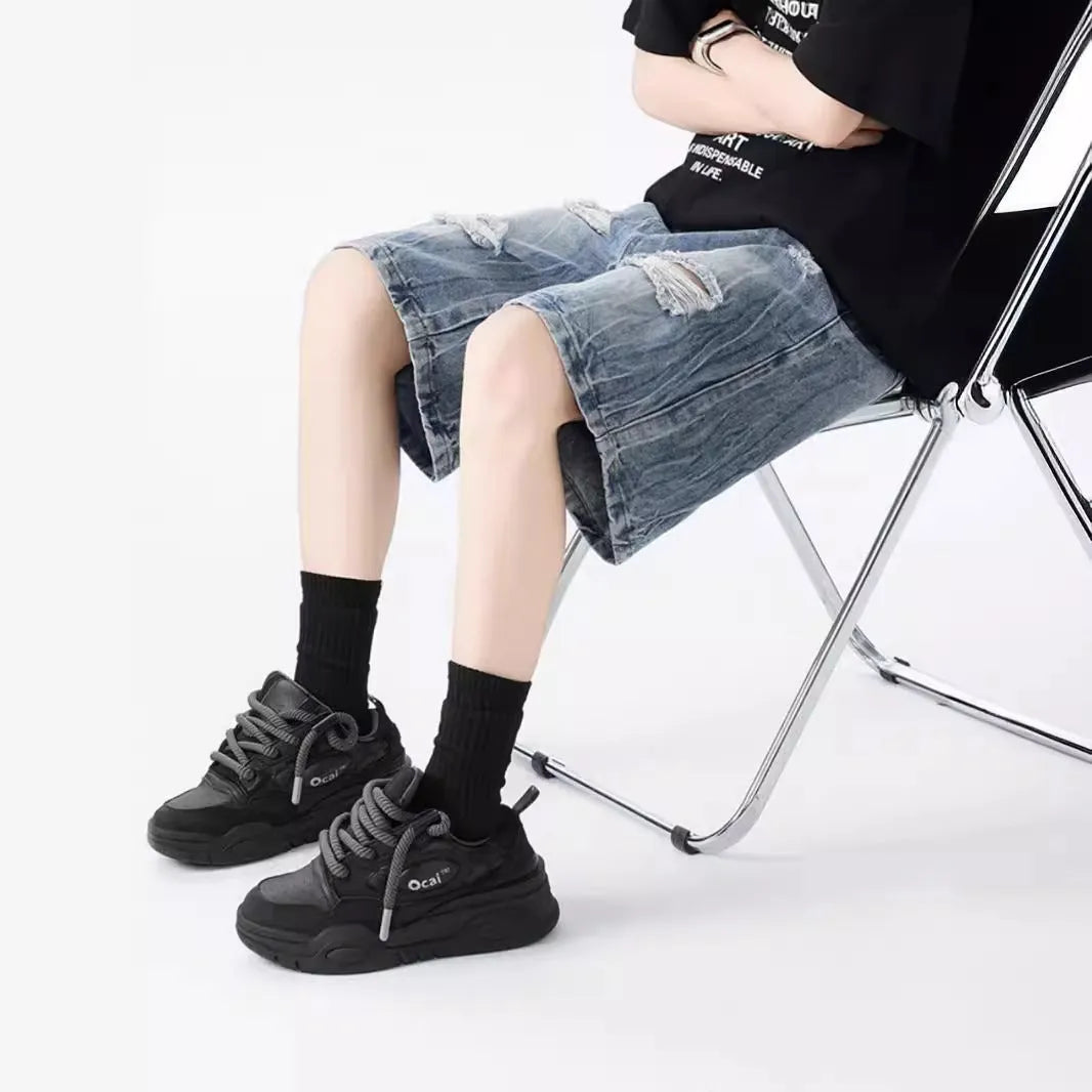 Men's loose fit distressed denim shorts in black vintage style with ripped detailing