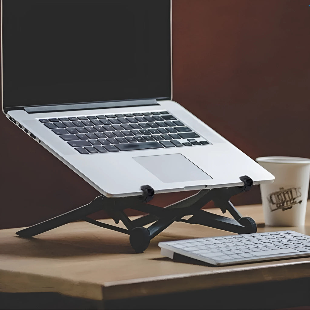 Folding computer bracket in sagacious black, made from enhanced nylon, with carrying case, on a desk with a laptop