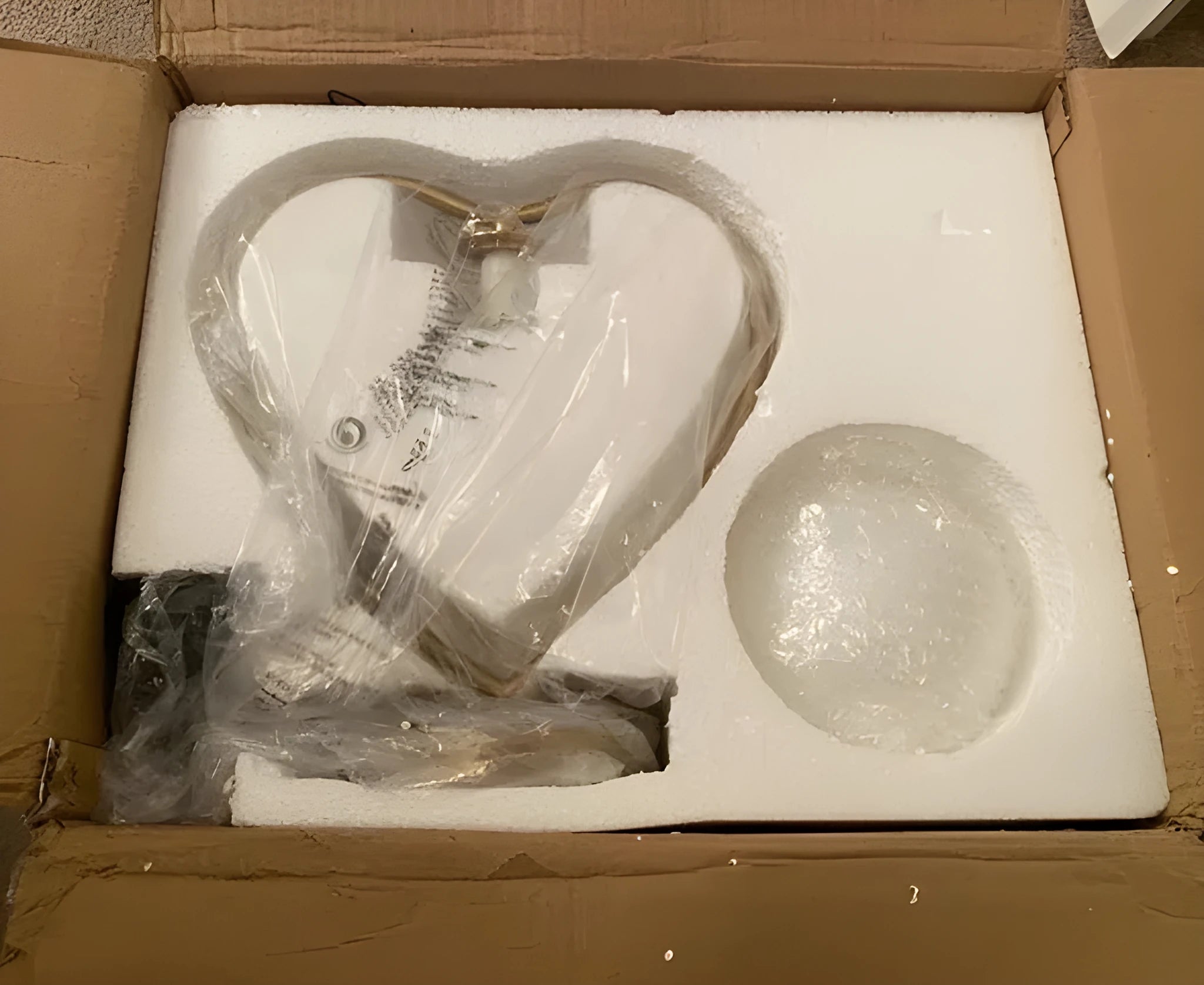Clear acrylic heart-shaped LED lamp with remote control on a wooden table.