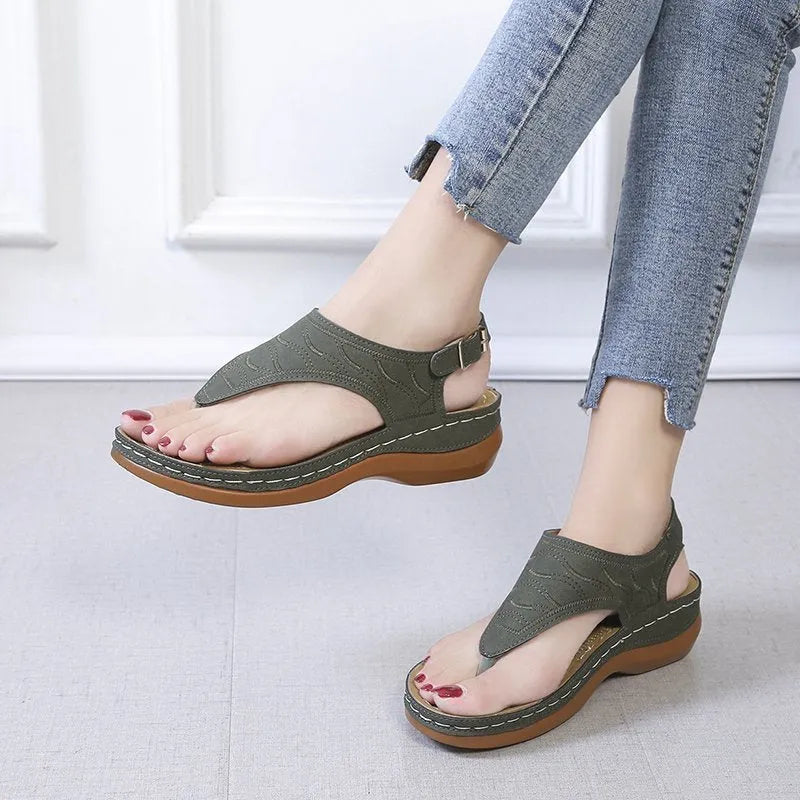 Women's red wedge heel flip flop sandals with an adjustable buckle strap on a white background.