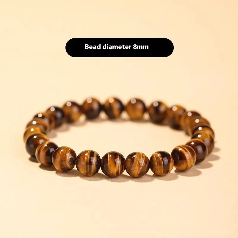 Single tigereye bead ethnic Buddha bracelet on wrist, showing simple rosary style.