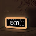 Blue rectangular LED atmosphere light alarm clock with digital display on a table.