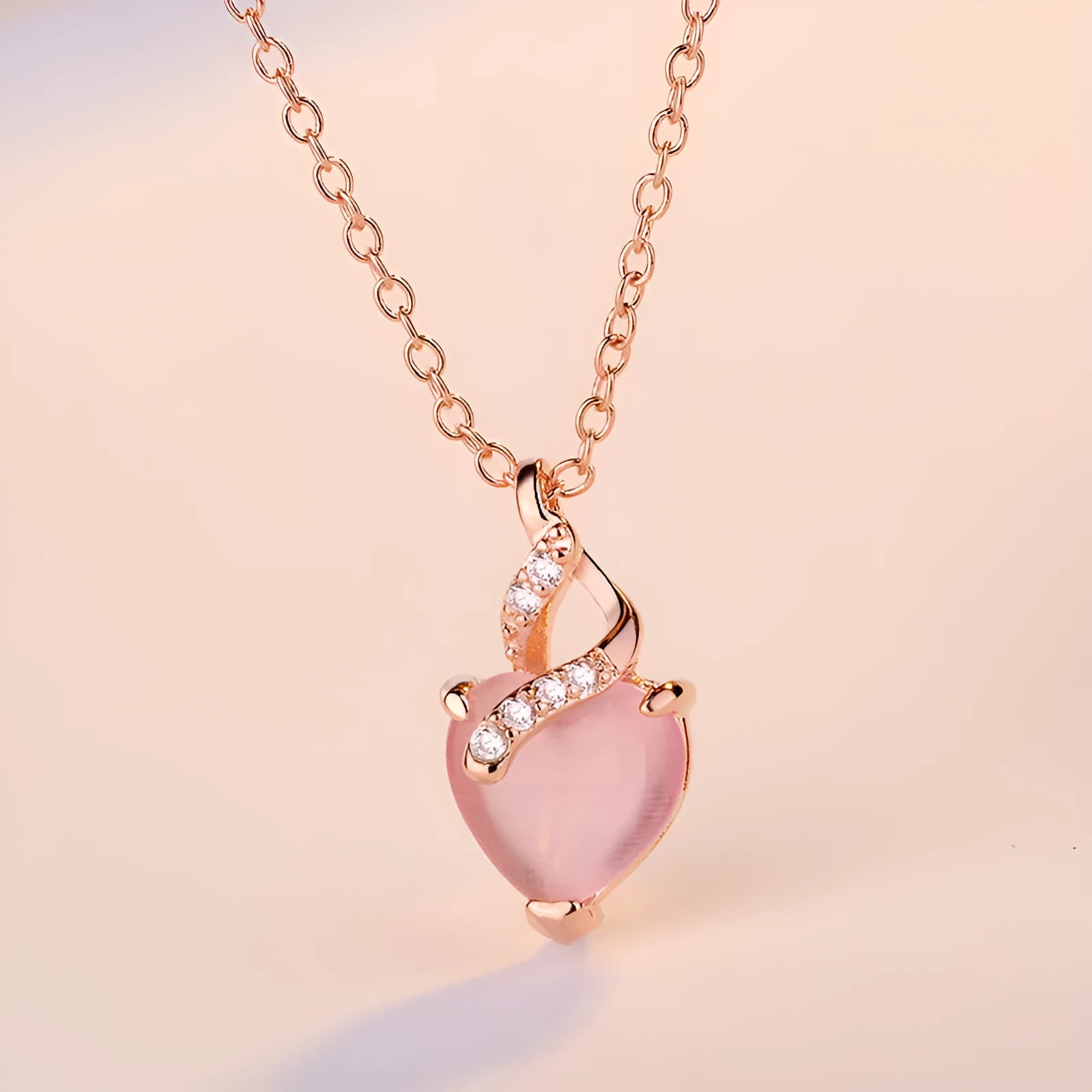 Rose gold women's necklace with heart-shaped pink crystal pendant on cross chain