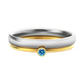 Close-up of a geometric titanium steel ring with an engraved December birthstone colour design on the band.