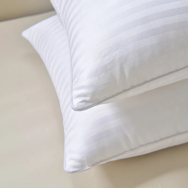 White hotel pillow with a satin stripe on a bed, showing low, medium, and high loft options.