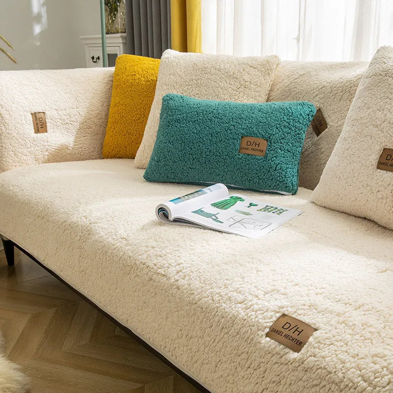 Beige plush lamb wool sofa cover with anti-slip backing laid flat on a modern grey sofa.