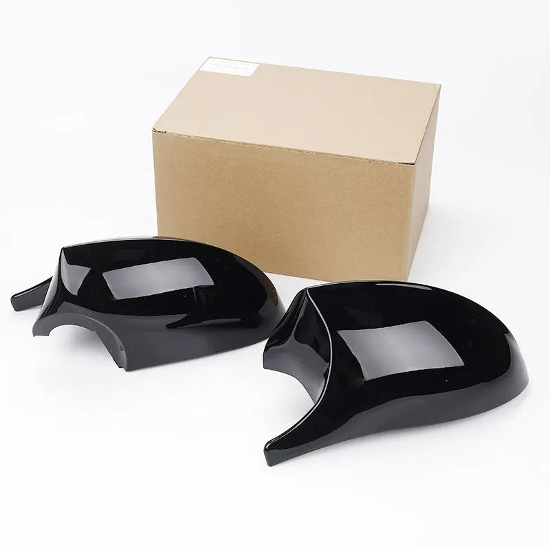 A pair of black ABS plastic rearview mirror shells for a BMW 3 Series E90 car.