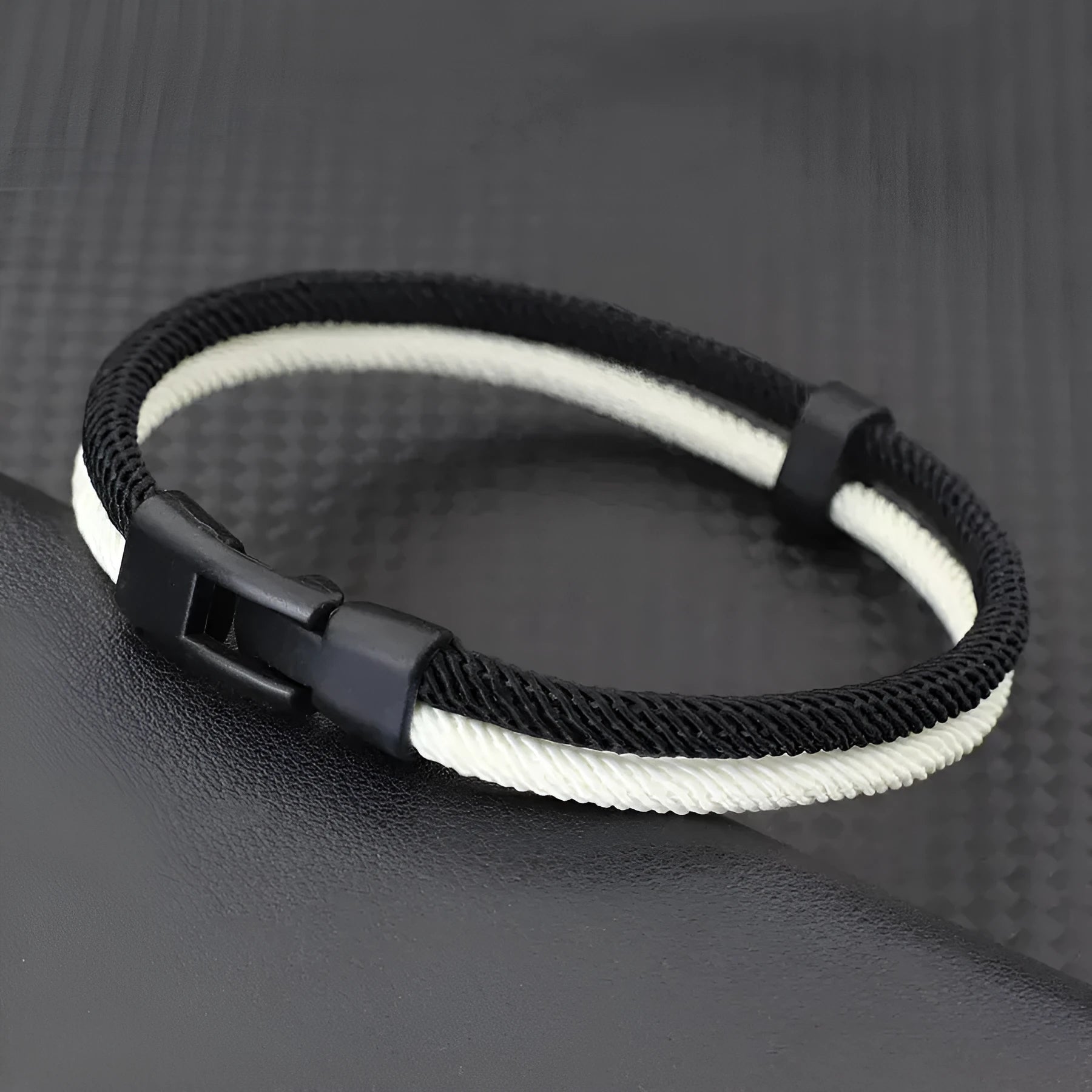 Black and white handwoven hand strap made from Milan rope alloy showing textured weave pattern