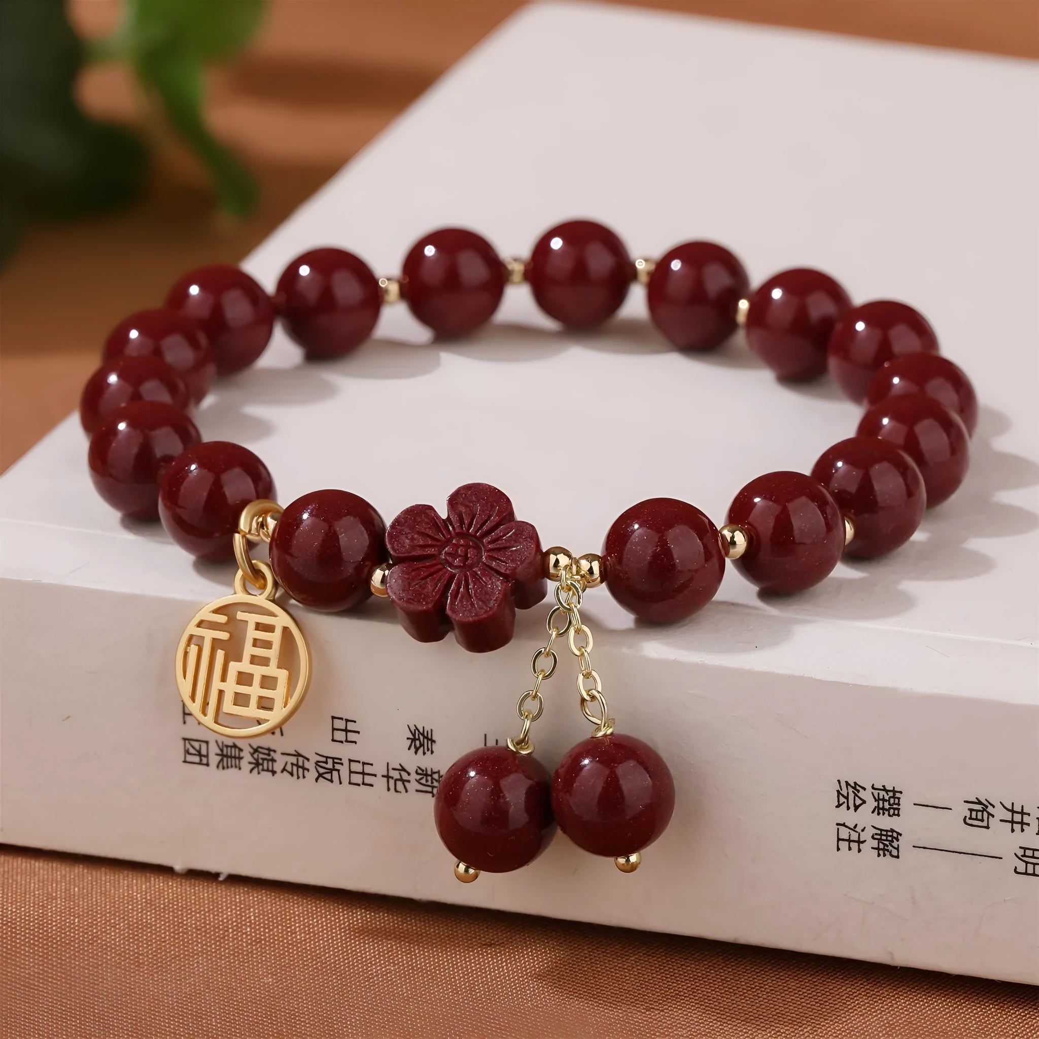 Close-up of a retro-style women's cinnabar bracelet with purple gold sand colour, showing fu character design and tassels.